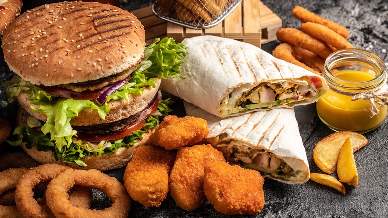 Platter of fast food with burgers, fries, wraps, and more