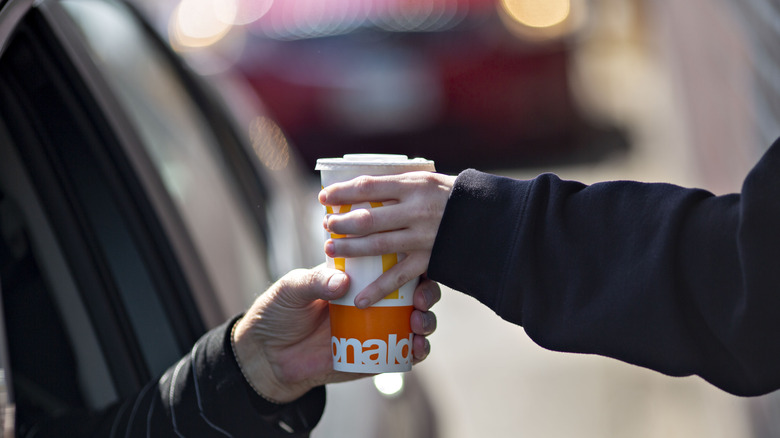 mcdonald's employee handing cup at drive-thru