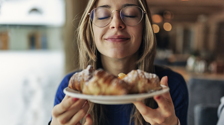 woman holding plate eyes closed