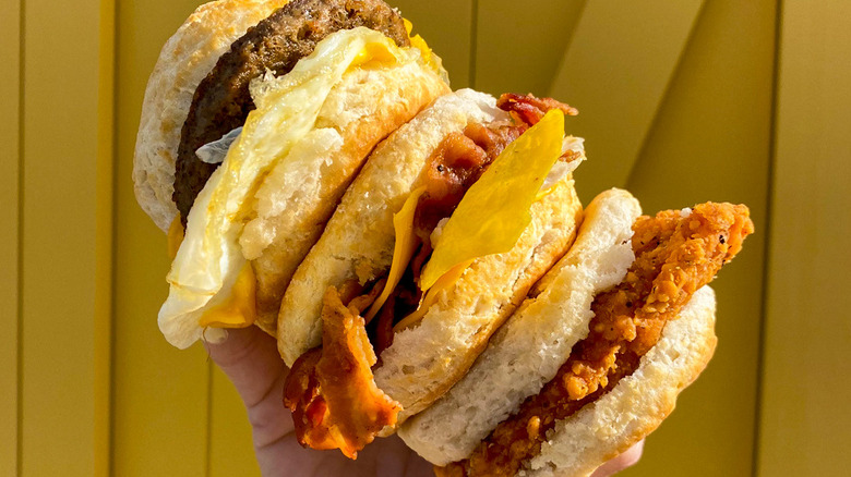 Hand holding three breakfast biscuits from Biscuitville