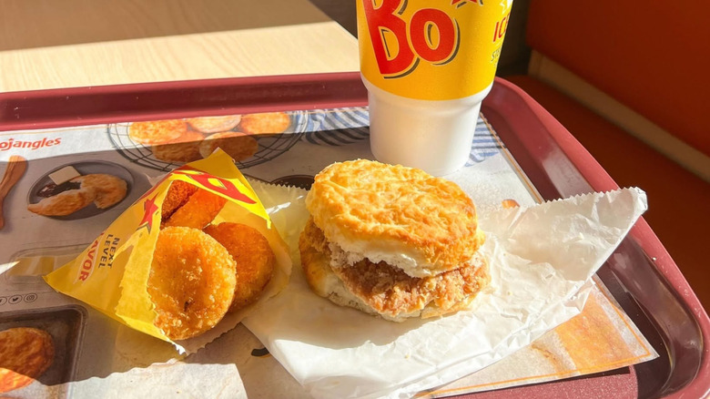 Bojangles breakfast biscuit on a tray with beverage and hash browns
