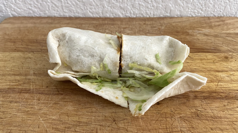 BBQ Chicken Wrap on cutting board, lettuce spilling out