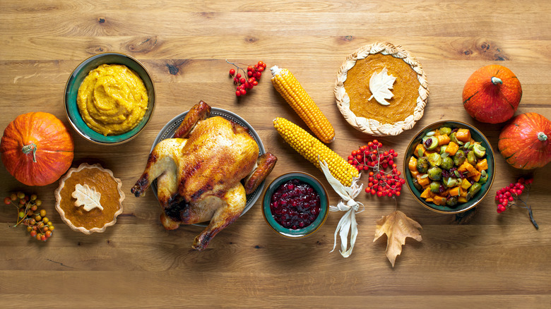 Traditional thanksgiving fare spread out on wooden table 