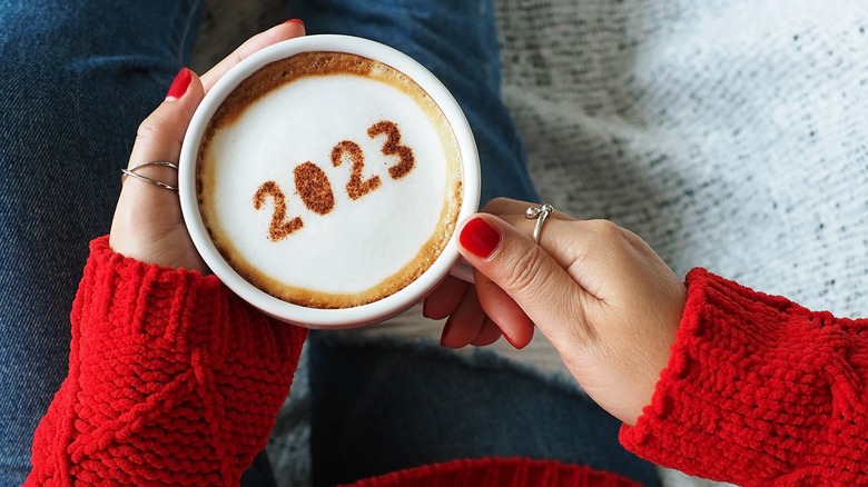 woman holding 2023 latte