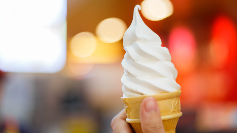 Person holding soft serve ice cream cone