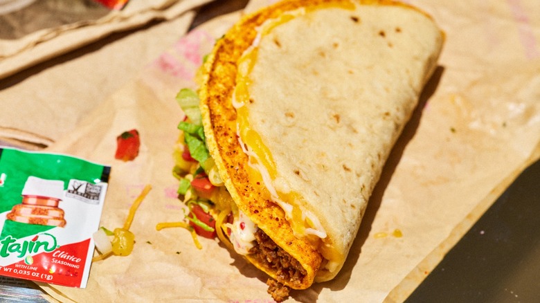 The Cheesy Gordita Crunch next to Tajín packet from Taco Bell.