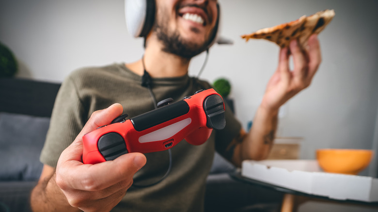 gamer with controller and pizza slice