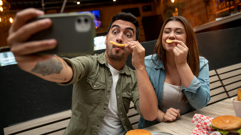 Couple taking photo with fast food