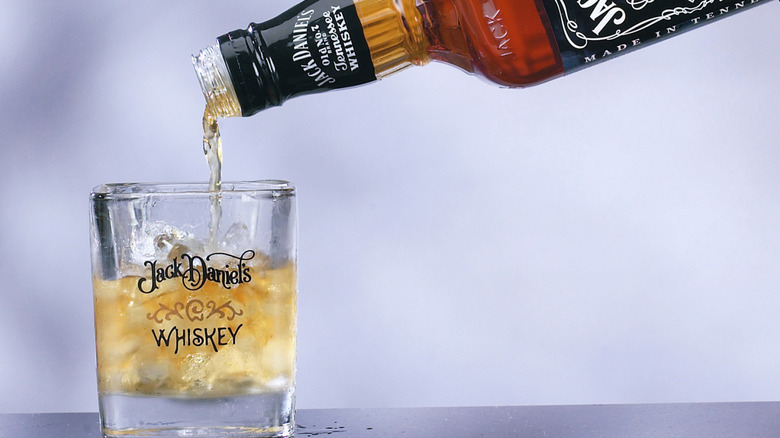 Pouring whiskey from a bottle of Jack Daniel's into a glass