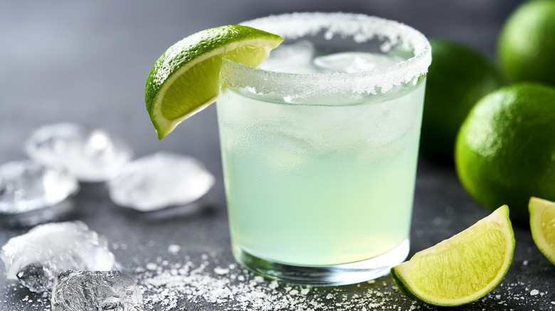Margarita over ice with a salt rim and a lime