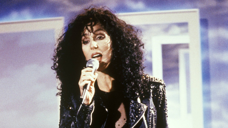 1980s icon Cher singing and wearing a black leather jacket