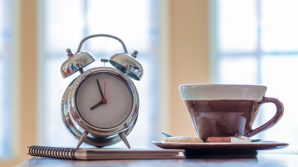 Alarm clock next to coffee mug