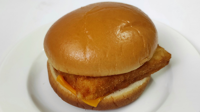 A Filet-O-Fish sandwich sitting on a white plate atop a white background