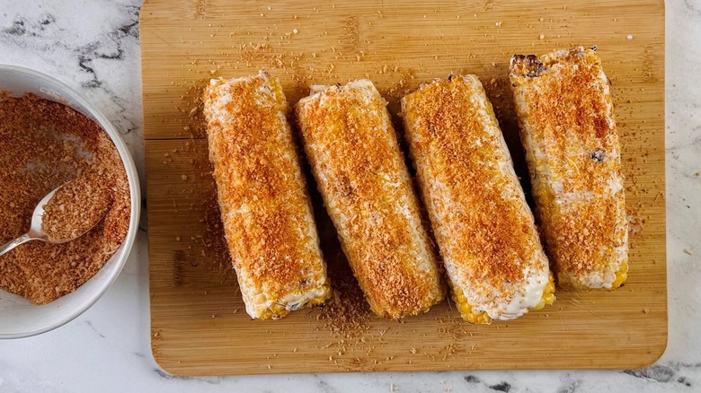 Corn cobs sprinkled with Parmesan paprika mixture