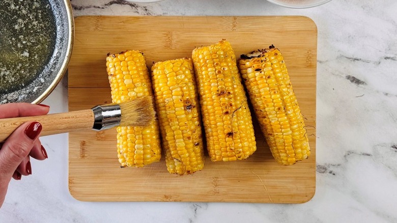 Pastry brush running over corn