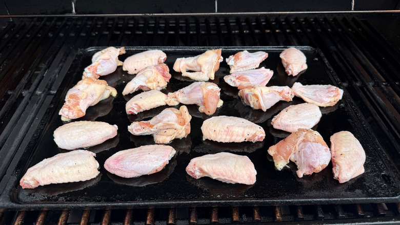 Raw chicken wings on grill