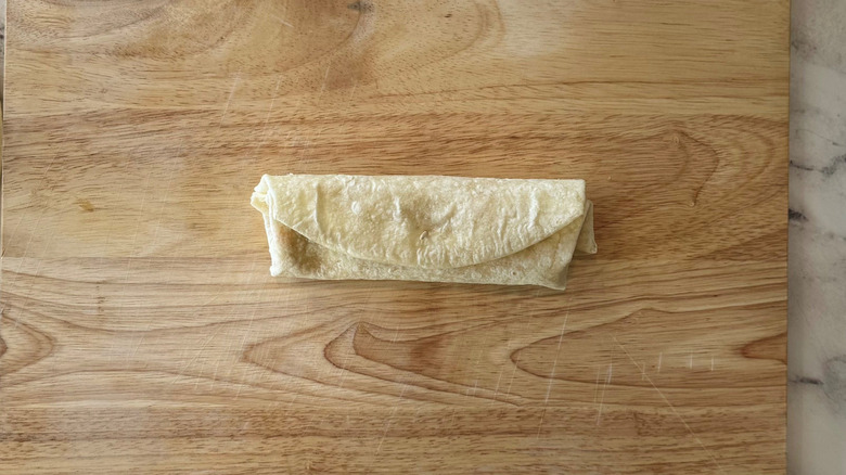 Small tortilla wrap on wooden board