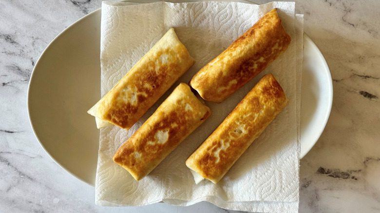 Tortilla wraps sitting on paper towel lined plate