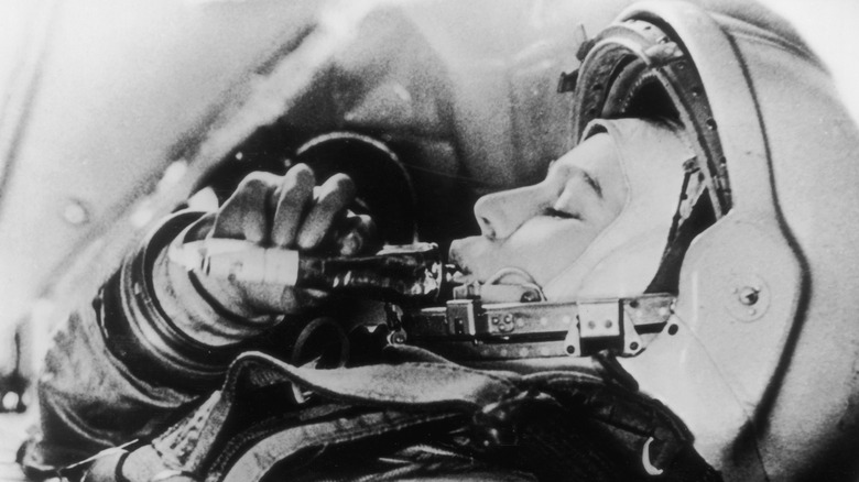 Black-and-white photo of an astronaut taking a sip of a beverage.