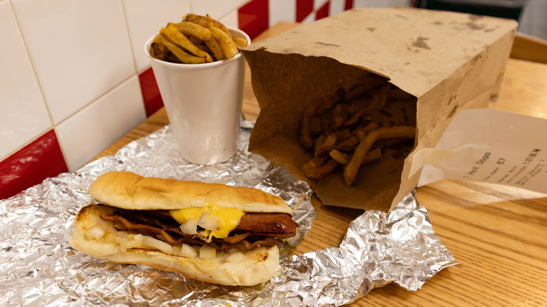 Five Guys bag and cup of fries with sandwich