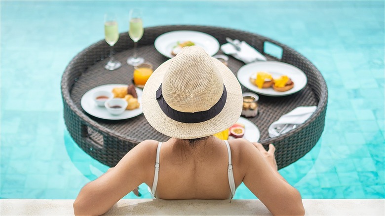 woman with hat faces floating breakfast