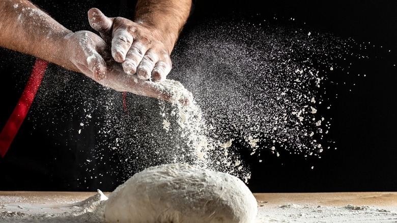 Hands dusting flour