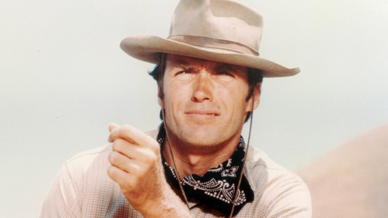 Vintage portrait of actor Clint Eastwood in Western hat and bandana squinting in the sun