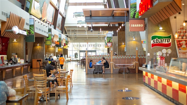 Mall food court with people eating in it