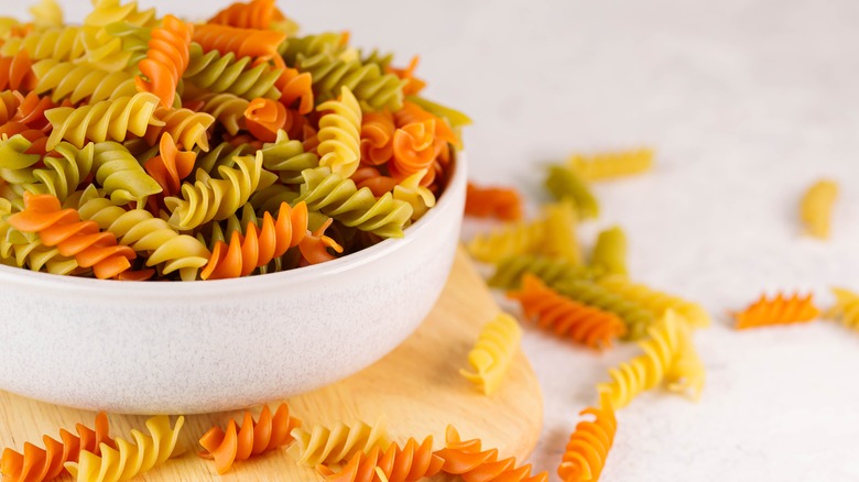 An overflowing bowl of dried tri-color rotini