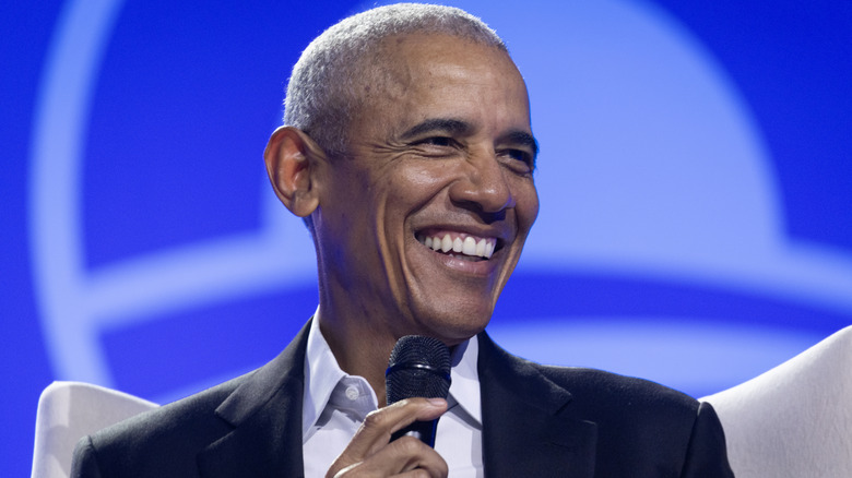 Barack Obama smiling during speaking engagement.