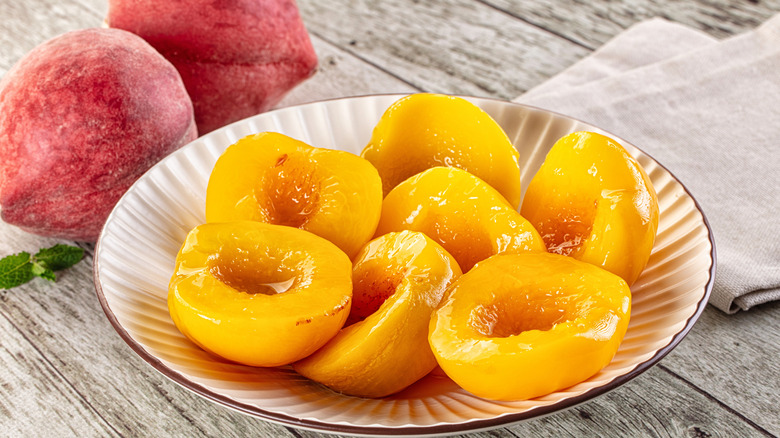 Fresh and canned peaches on a plate