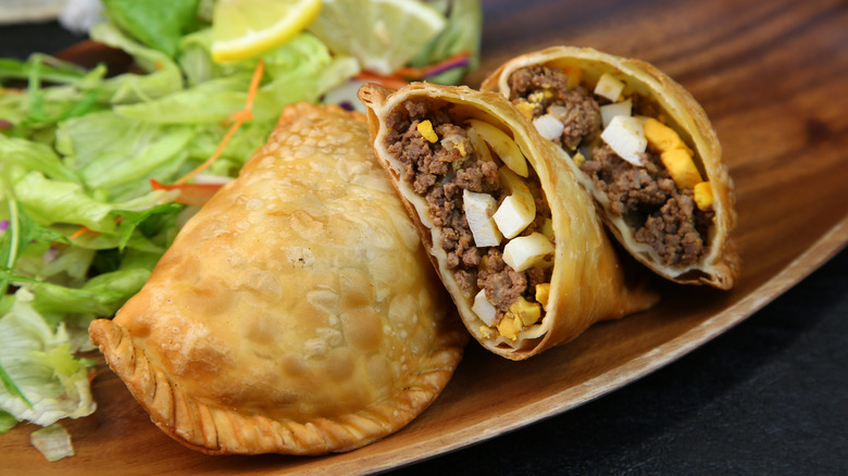 Empanadillas with one sliced in half to reveal the filling