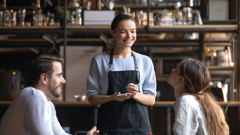 restaurant worker taking orders from couple