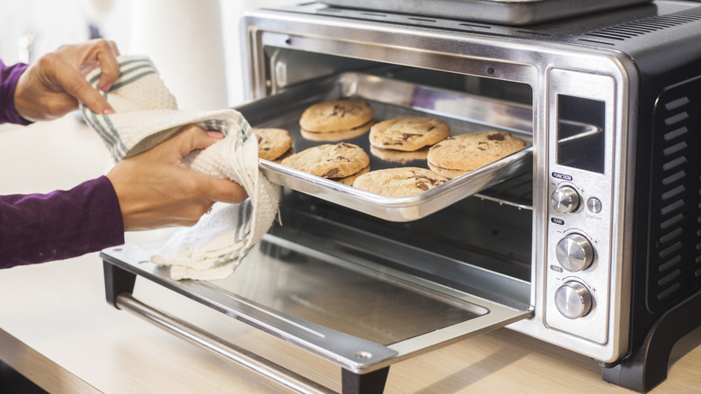 Person removing cookies from toaster oven