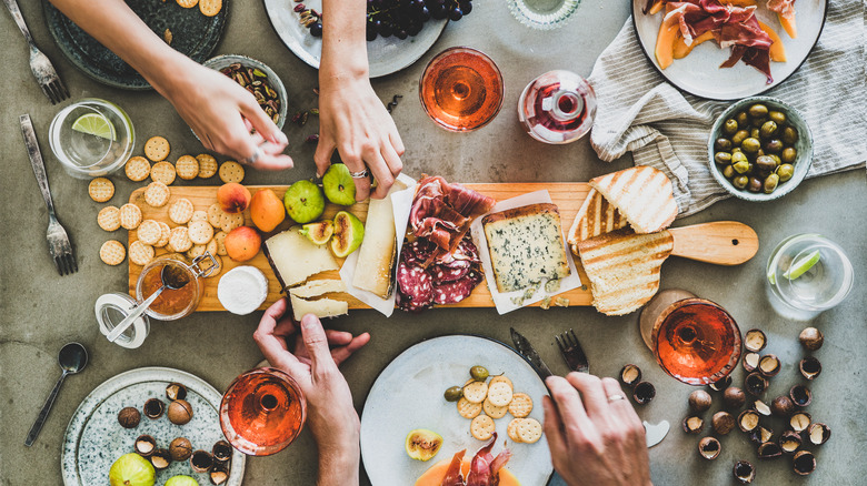 hands over a charcuterie board