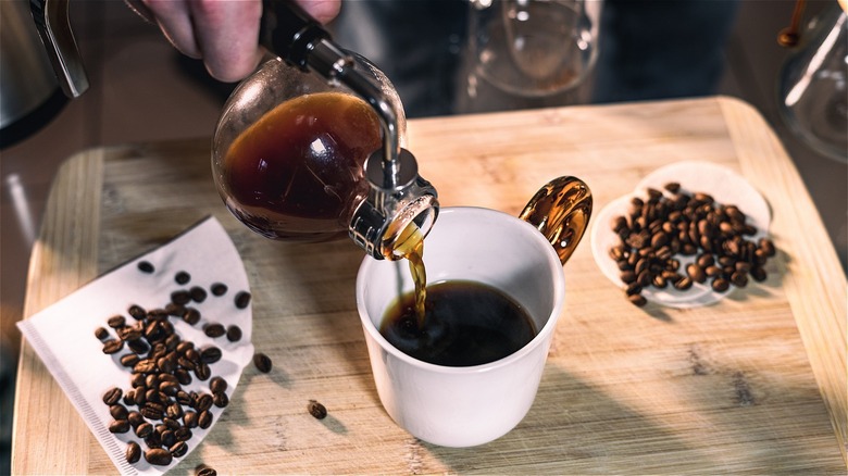 Man pouring coffee from siphon