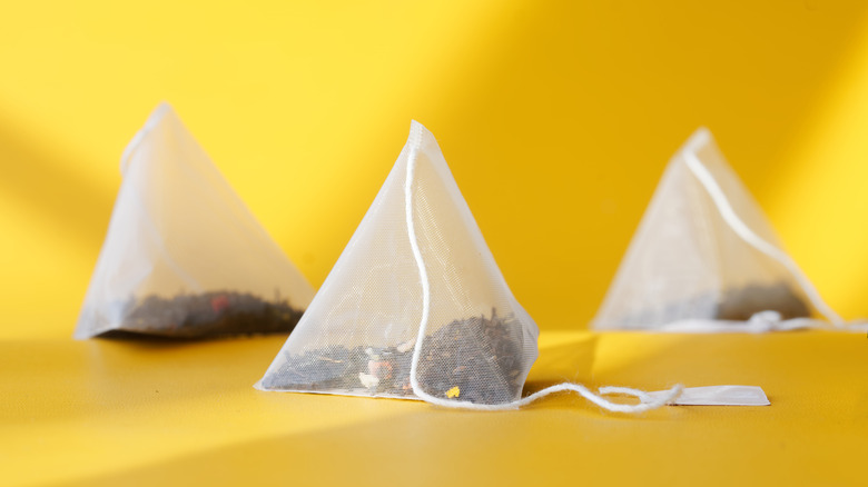 Pyramid tea bags over a yellow background