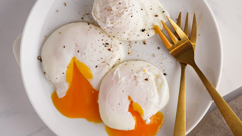 Three runny poached eggs on plate