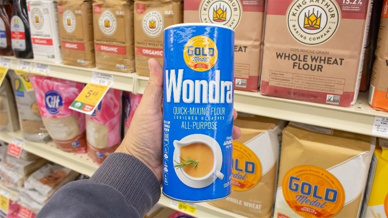 Hand holding a canister of Wondra quick-mixing flour