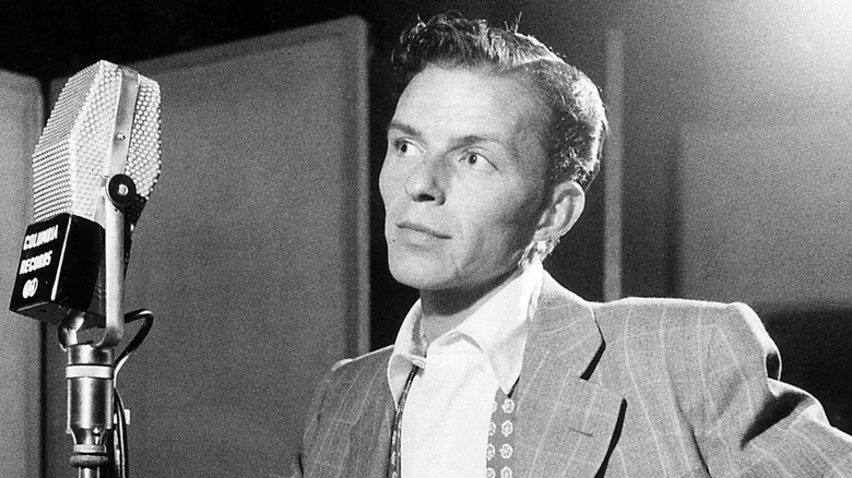 Young Frank Sinatra standing at a microphone