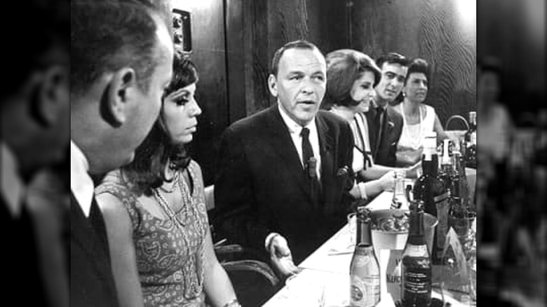 Frank Sinatra sits at a table with his family and other guests at Jilly's in New York