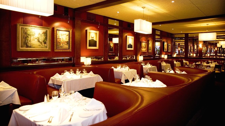 The interior of Matteo's Italian Restaurant with red leather booths and tables with white tablecloths.