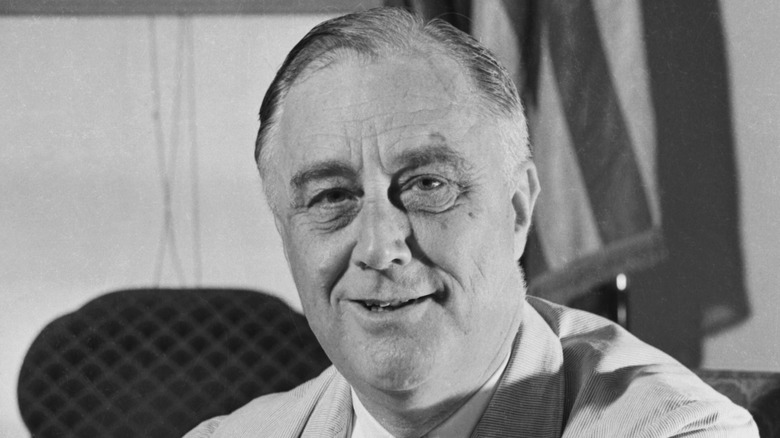 Franklin D Roosevelt smiling at his desk