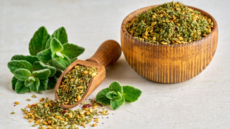 Small wooden bowl of za'atar seasoning with fresh oregano