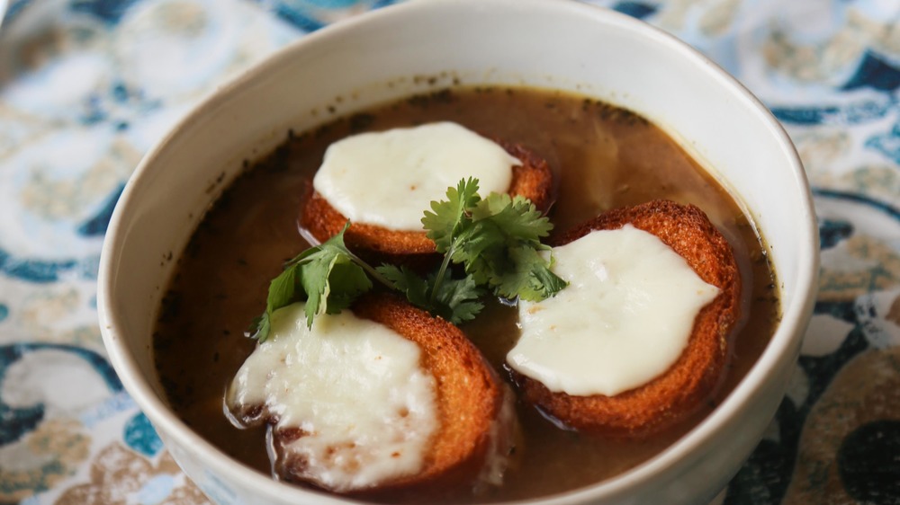 French onion soup in bowl with baguettes and cheese