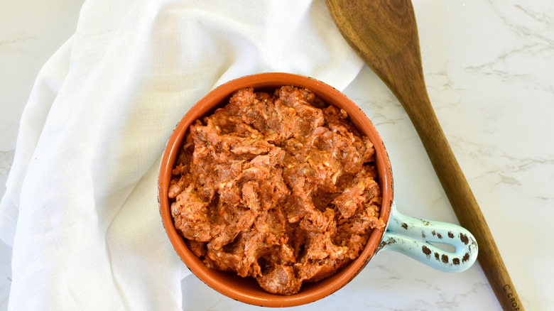uncooked chorizo with wooden spoon
