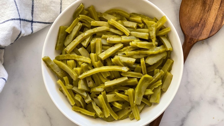 Fresh Nopalitos strips in bowl with wooden spoon