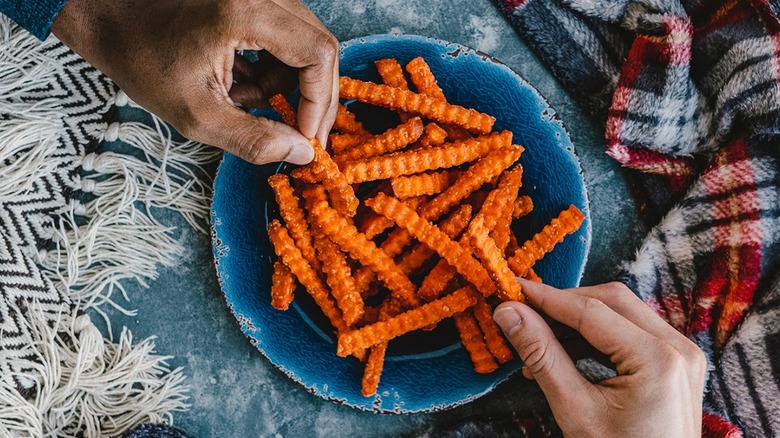 Hands reaching for sweet potato fries