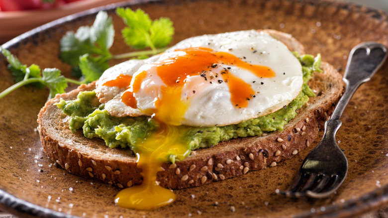 A runny fried egg over avocado toast