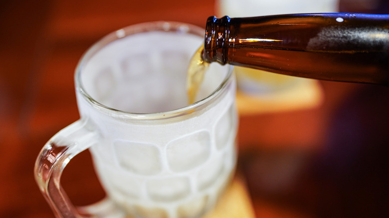 Pouring beer into frosted mug